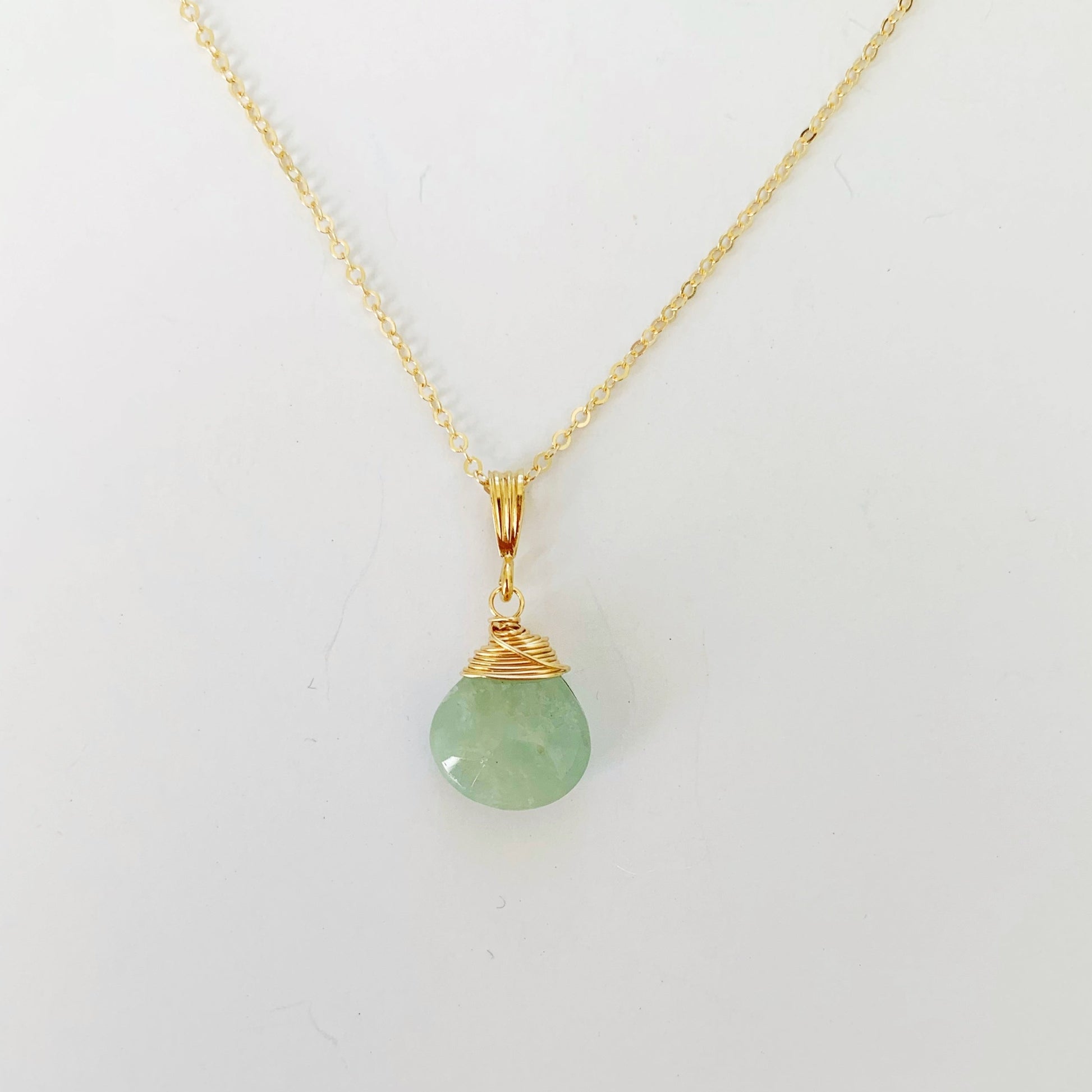raindrop aqumarine 14k gold filled wire wrapped pendant necklace pictured here on a white surface