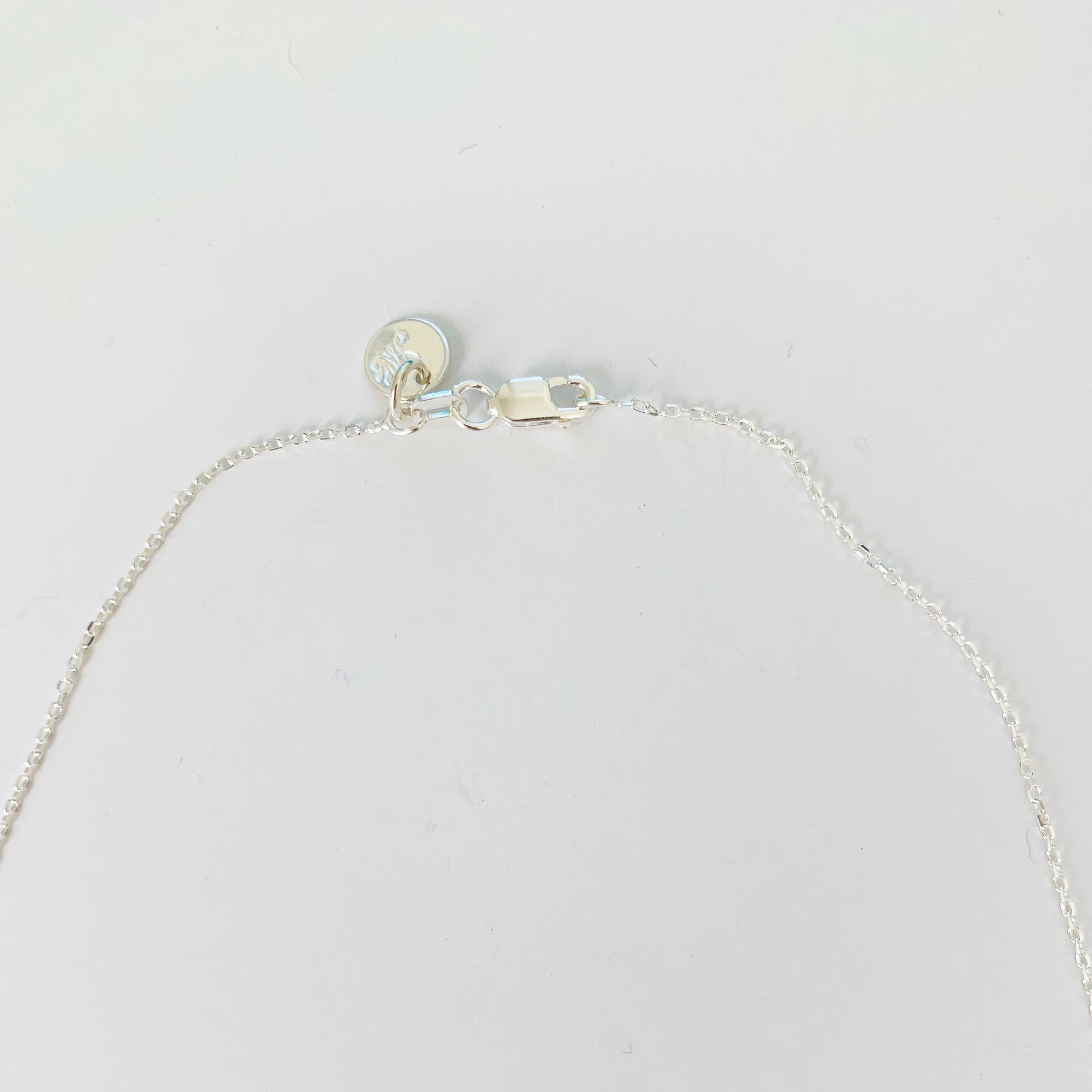 the back of the raindrop necklace is clasped with a lobster claw shown here 