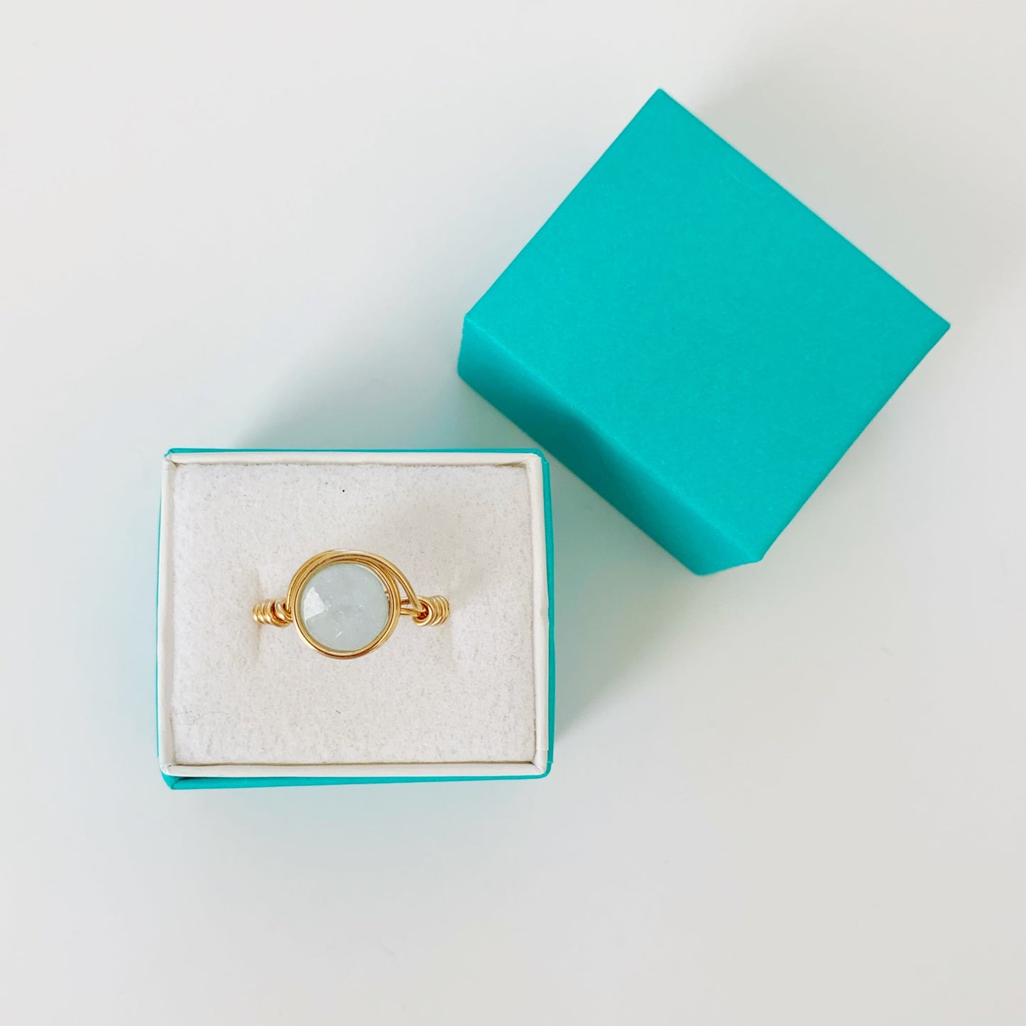 Raindrop wire wrapped aquamarine and 14k gold filled ring photographed in a teal ring box on a white surface