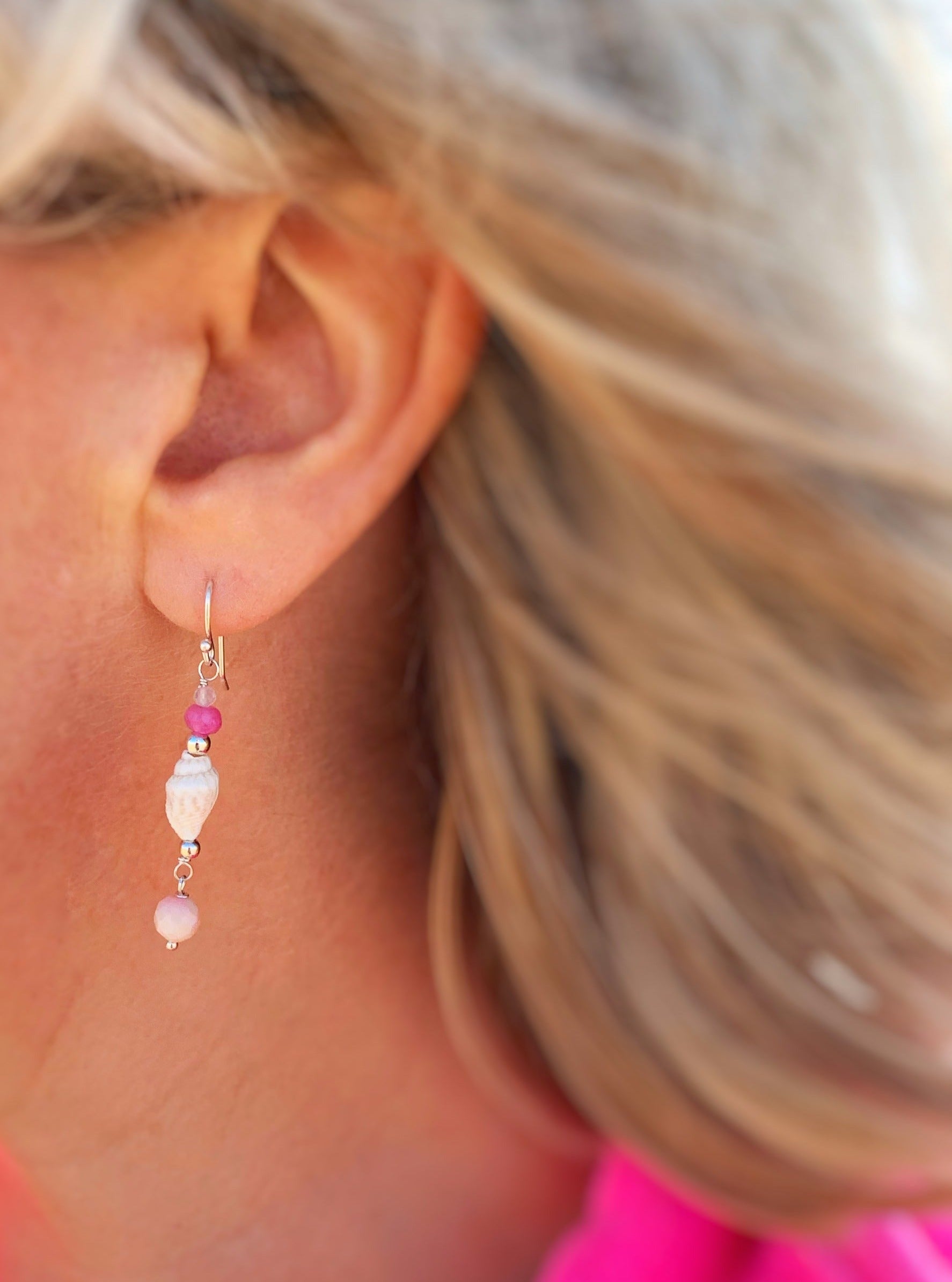 The pink flamingo shellebration earring from mermaids and madeleines is pictured worn here with a close up photo of the earring on an ear