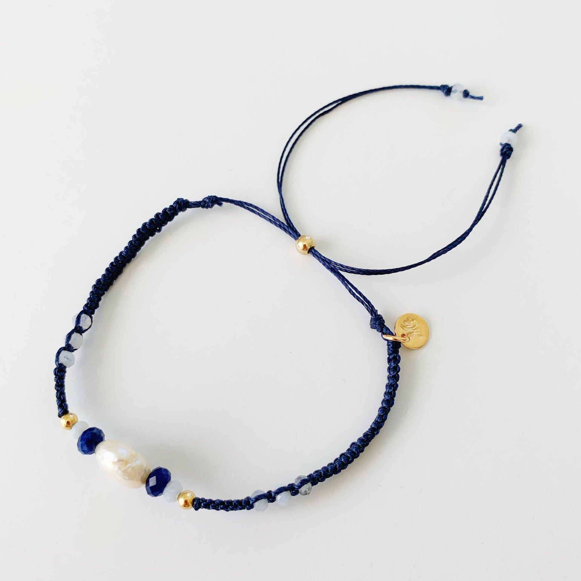 top view of the navy blue macrame friendship bracelet photographed on a white background